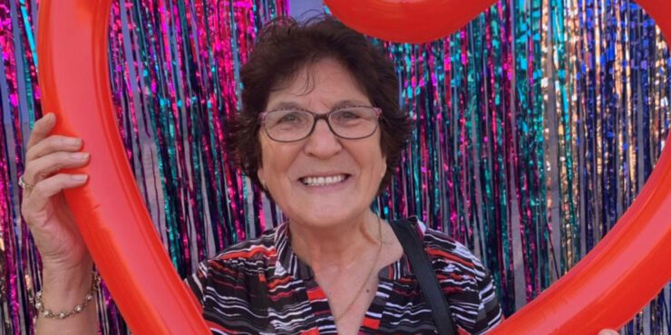 Rina smiles at the camera surrounded by a red heart.