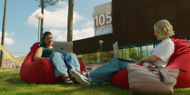 Two female students sitting on beanbags and working on laptops at the Curtin Bentley campus.