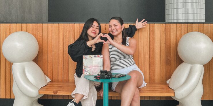 Celena and Devna making a heart with their hands.