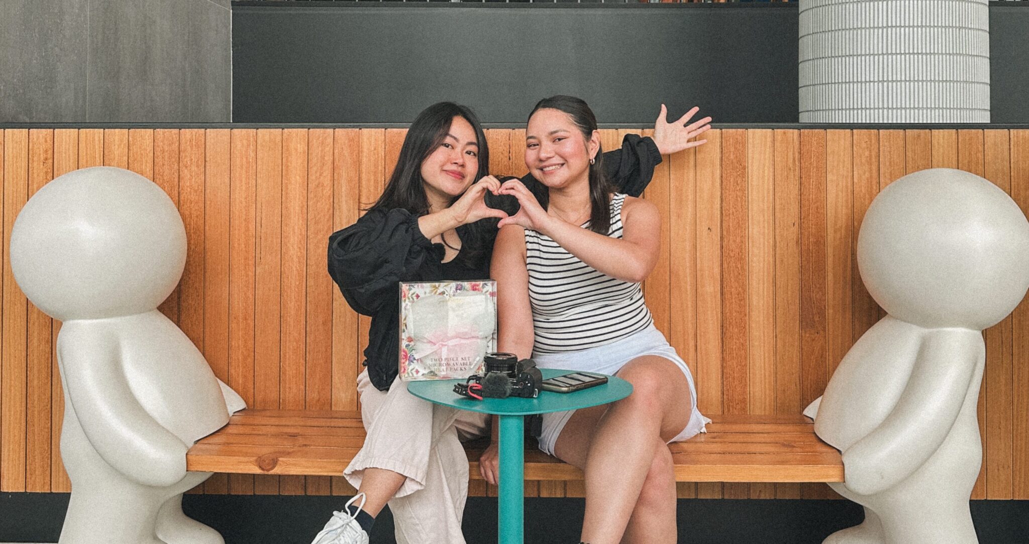 Celena and Devna making a heart with their hands.