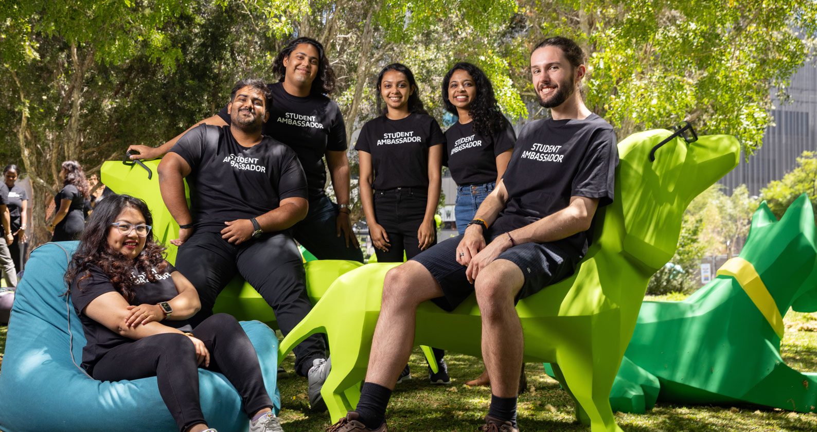 Student ambassadors sitting on green plastic animal chairs.