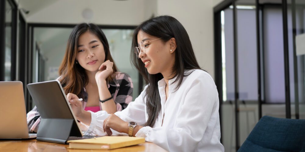 A female university student and staff member working on digital tablet.  Visualises the capstone experience at Curtin University. 