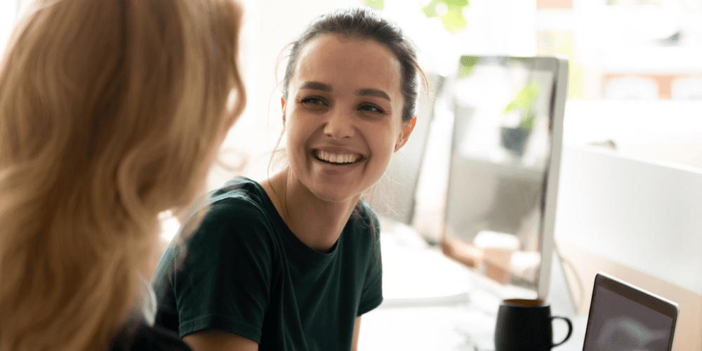 Young person in an office, smiling. Example of capstone unit experiences at Curtin University. 