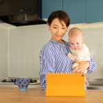 Mother holding infant using digital tablet