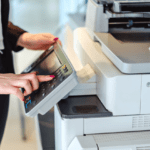 A female using a printer in an office.