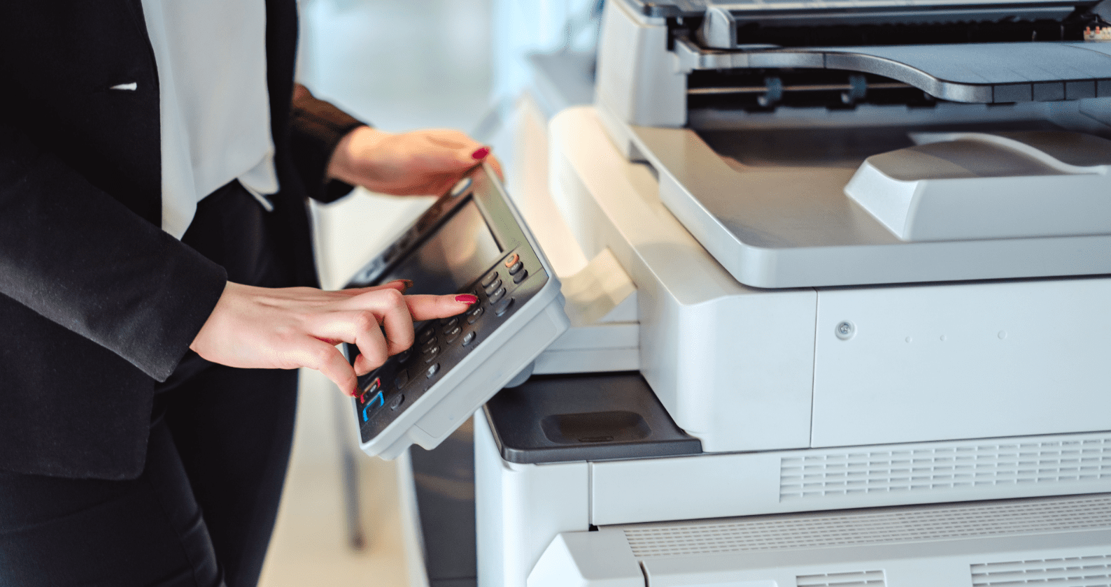 A female using a printer in an office.