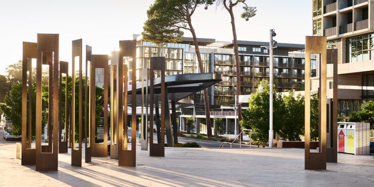 A photo of buildings and an art installation on the Curtin Perh campus at sunset.