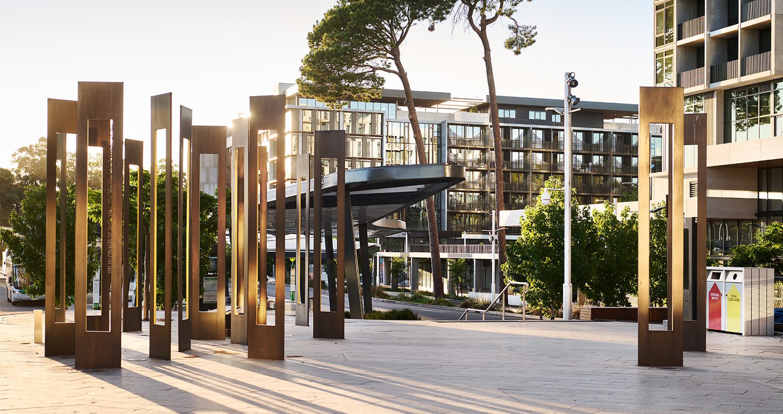 A photo of buildings and an art installation on the Curtin Perh campus at sunset.