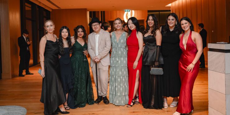 A group of students wearing gowns and suits for a ball.