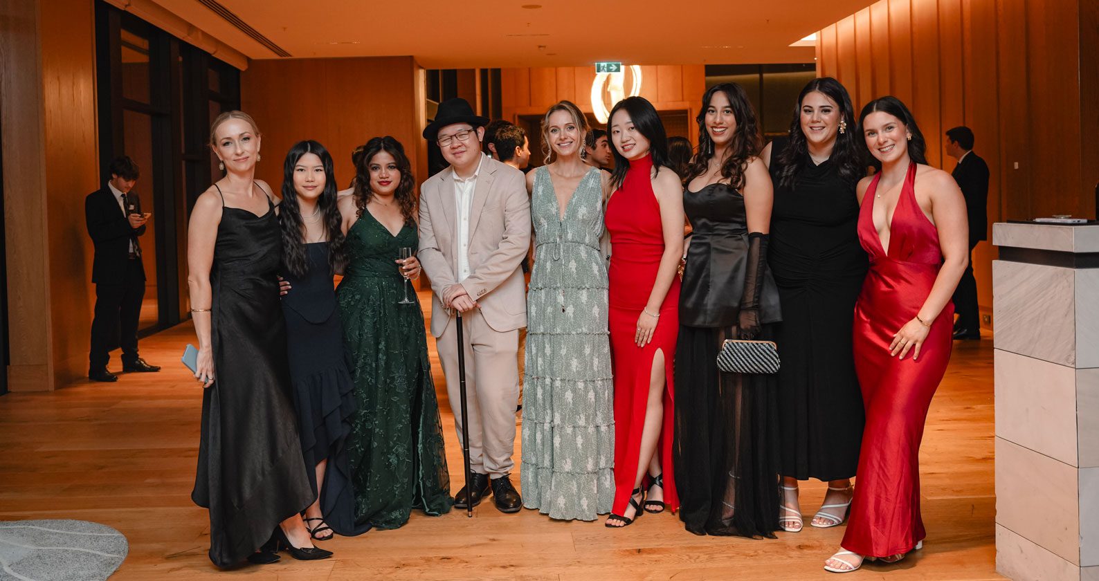A group of students wearing gowns and suits for a ball.