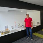 An image of Essam in front of an exhibition.