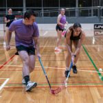 People playing floorball indoors.