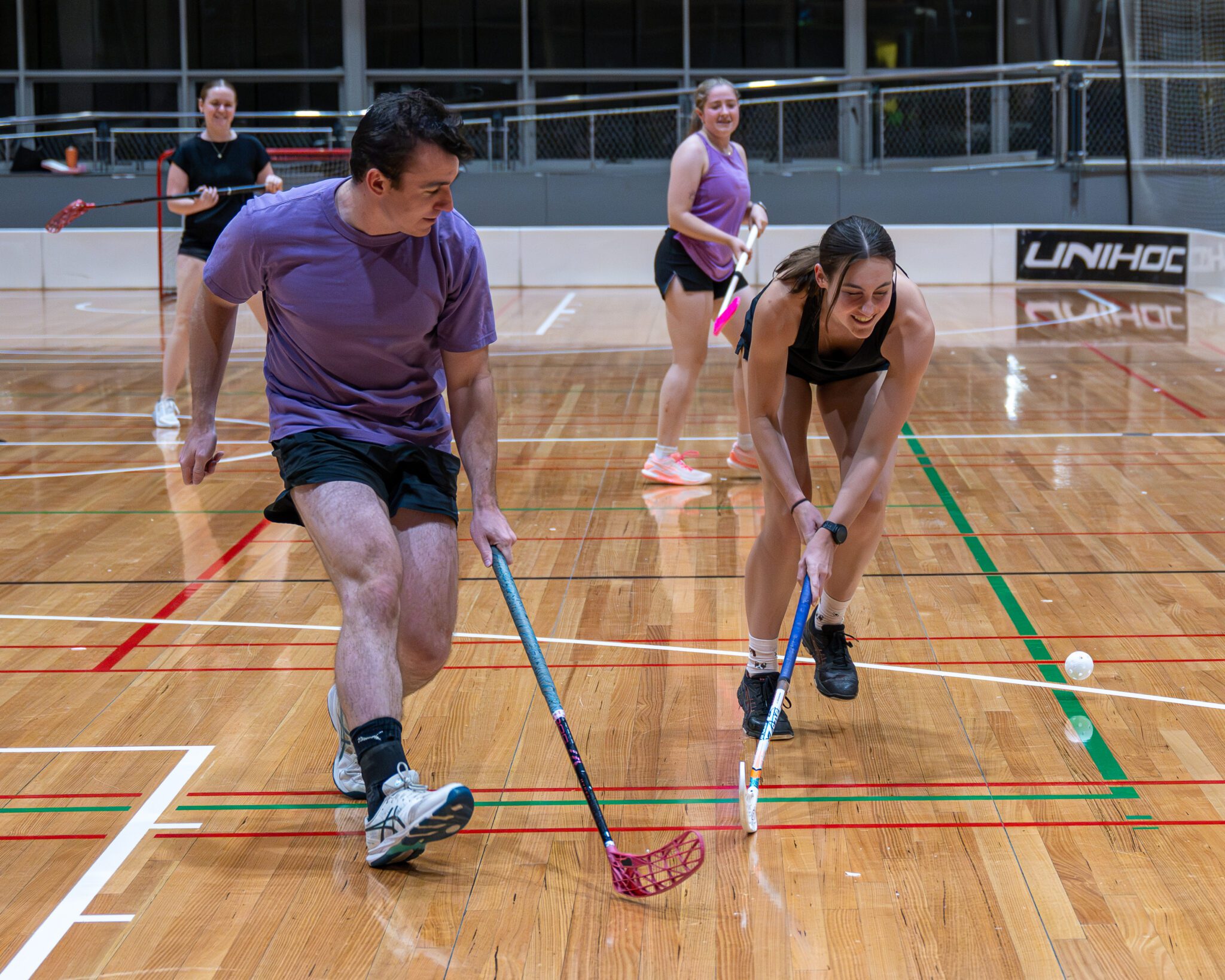People playing floorball indoors.