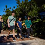 Four students walking together outdoors at Curtin Perth.