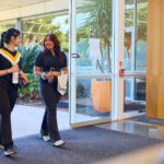 Two students walking into the Curtin Stadium reception area.