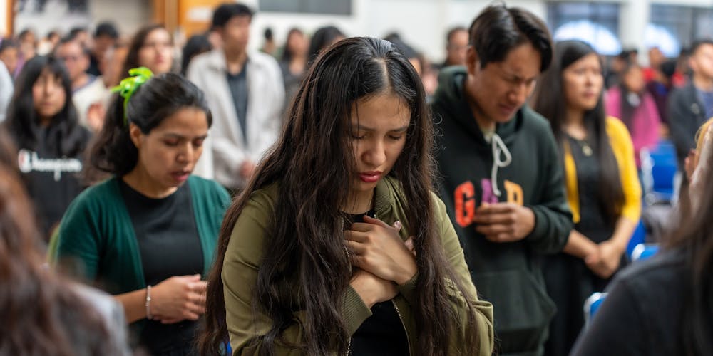 A large group of people engaged in a spiritual gathering and prayer