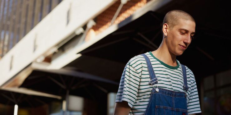 Student walks down a path next to a concrete building.