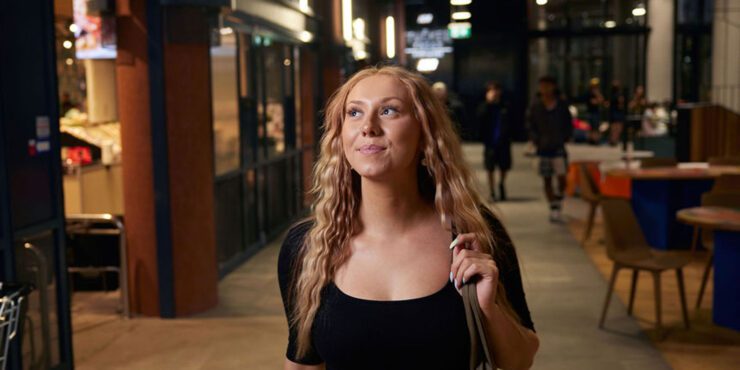 Student walking down an outside corridor.