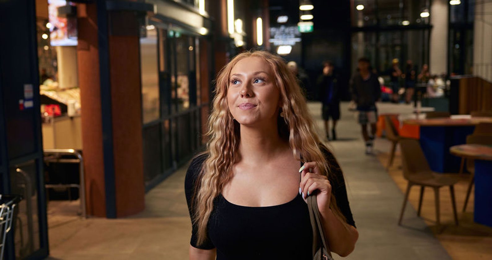 Student walking down an outside corridor.