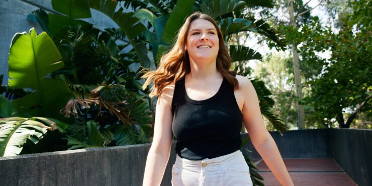 A young woman walking through campus.