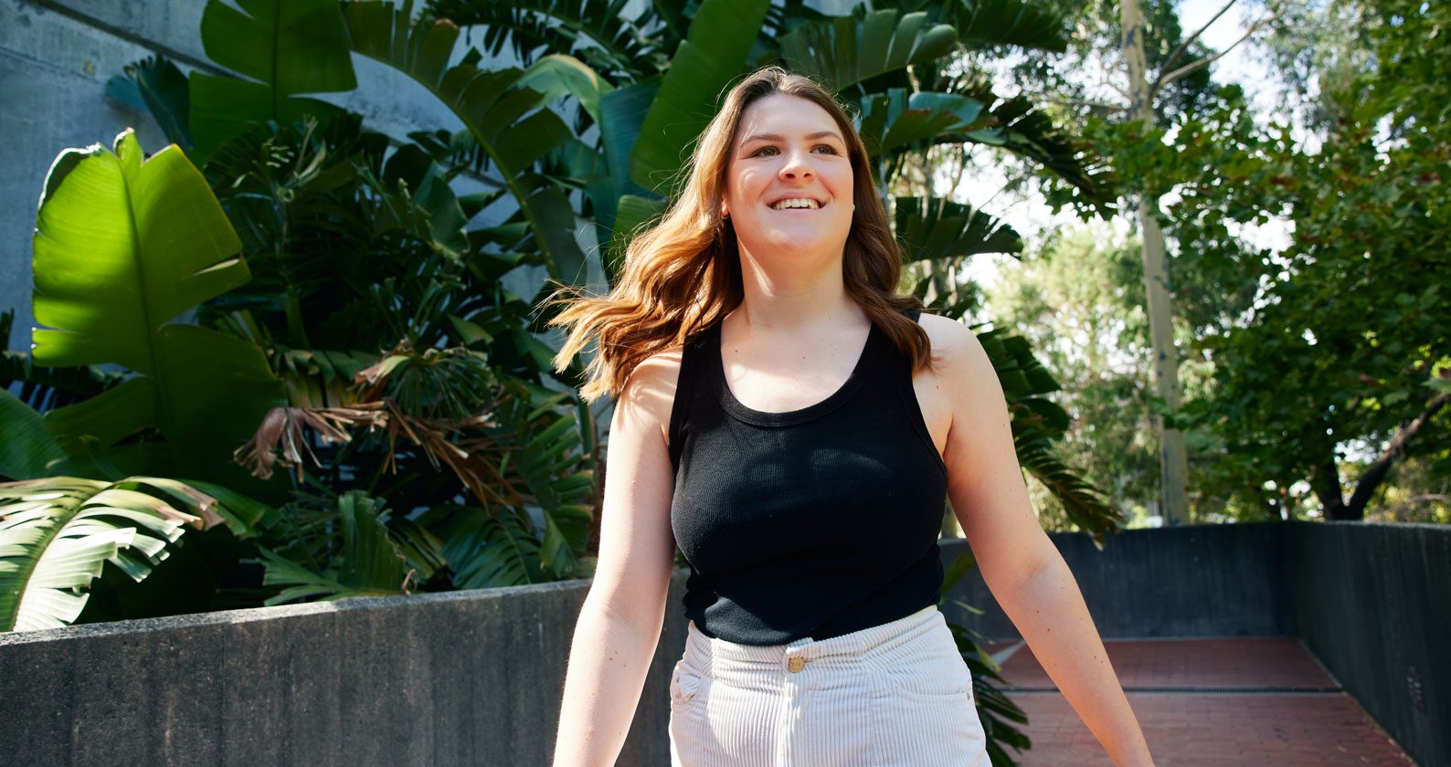A young woman walking through campus.