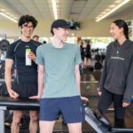 Three students in the Curtin Stadium gym surrounded by equipment.