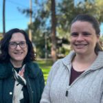 Mary and Kirsten stand side by side on campus.