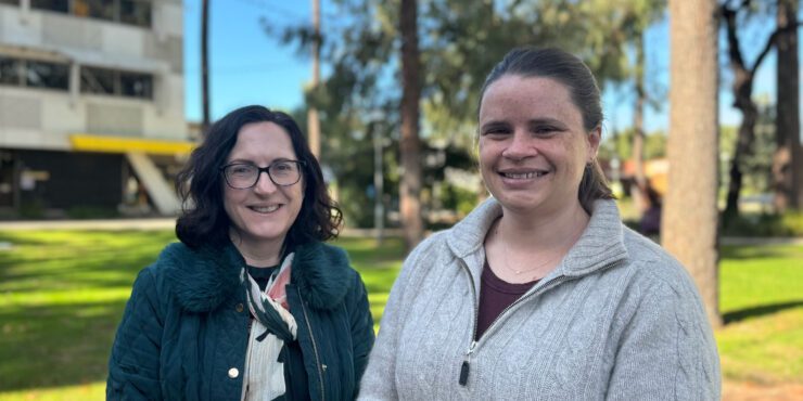 Mary and Kirsten stand side by side on campus.