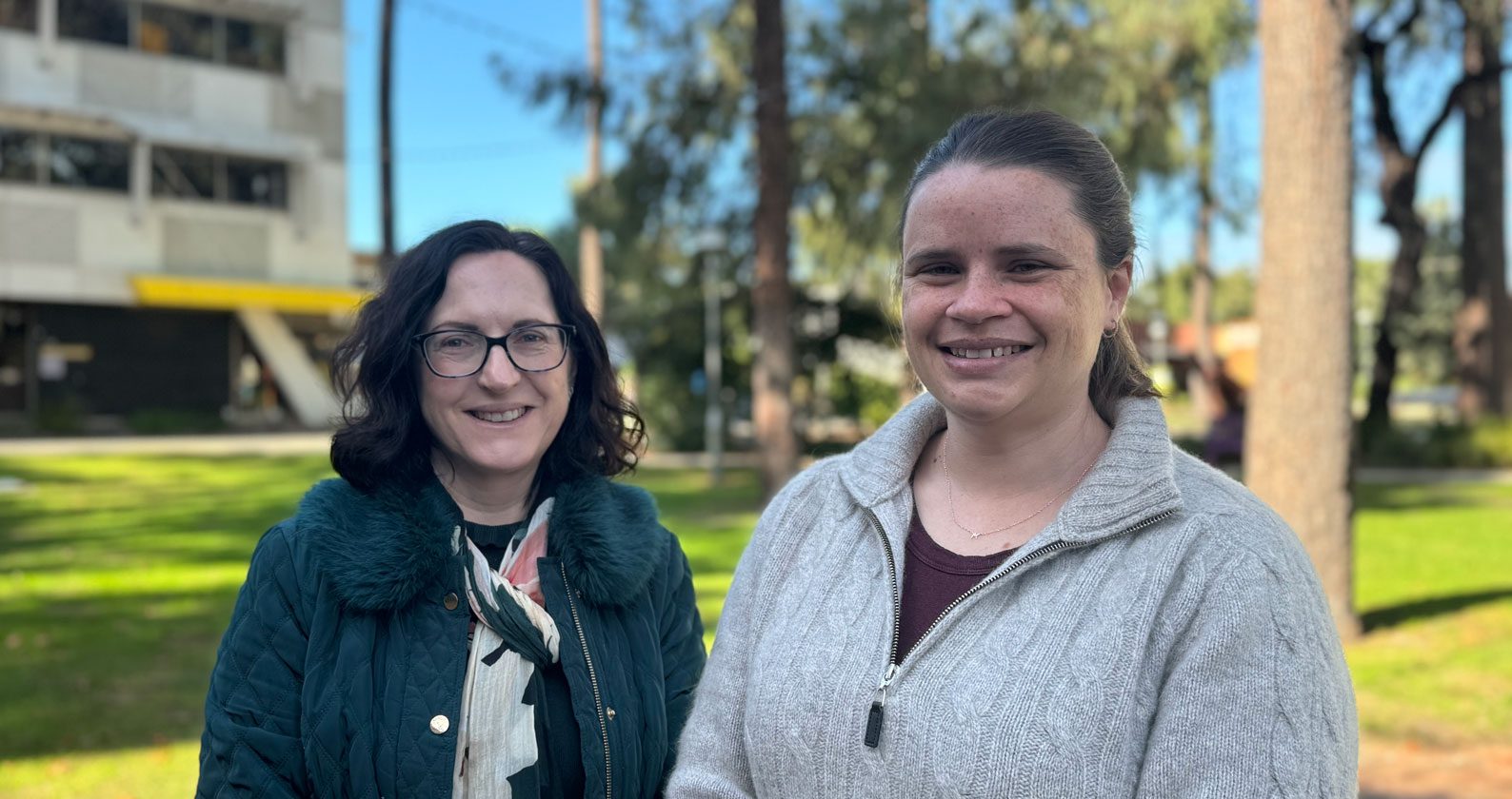 Mary and Kirsten stand side by side on campus.