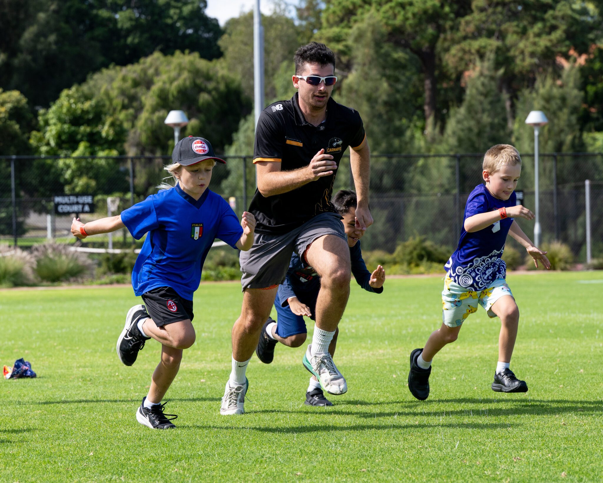 Image of two children sprinting alongside a Curtin Carnaby Coach