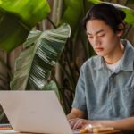 Student typing on laptop.