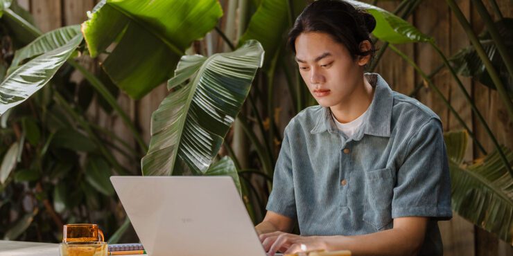 Student typing on laptop.