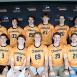 Curtin Carnabys team members smiling in front of a black backdrop.