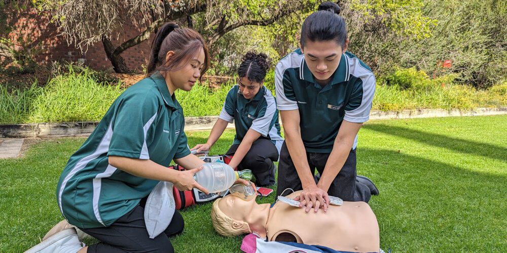 Three Curtin paramedic students work on a patient.