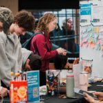 A group of students standing at a table with snacks, pens and informational materials.