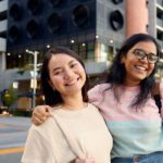 Two Curtin students smiling in front of their accommodation.