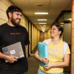 Two Indigenous students walk down a hallway.