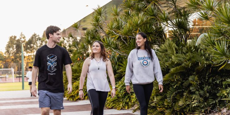 Three students walking towards Curtin Stadium