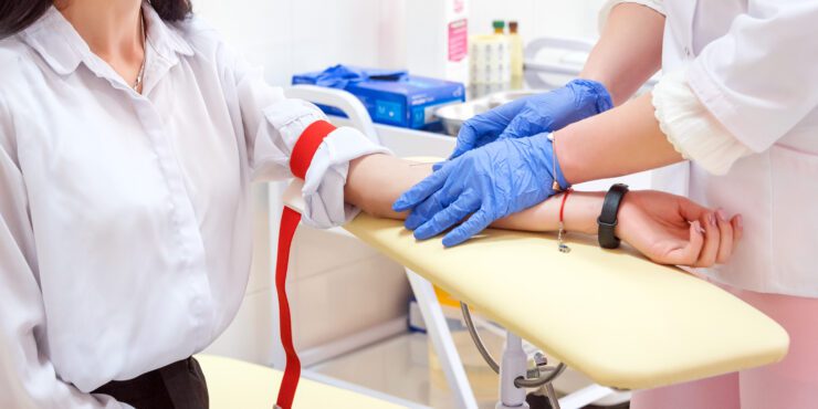 An OT student with a patient pointing to a replica spine.