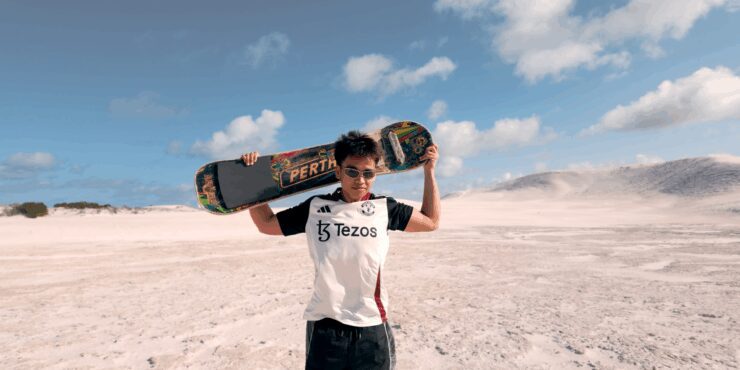 Image of Musa holding a sand board at the sand dunes in Lancelin