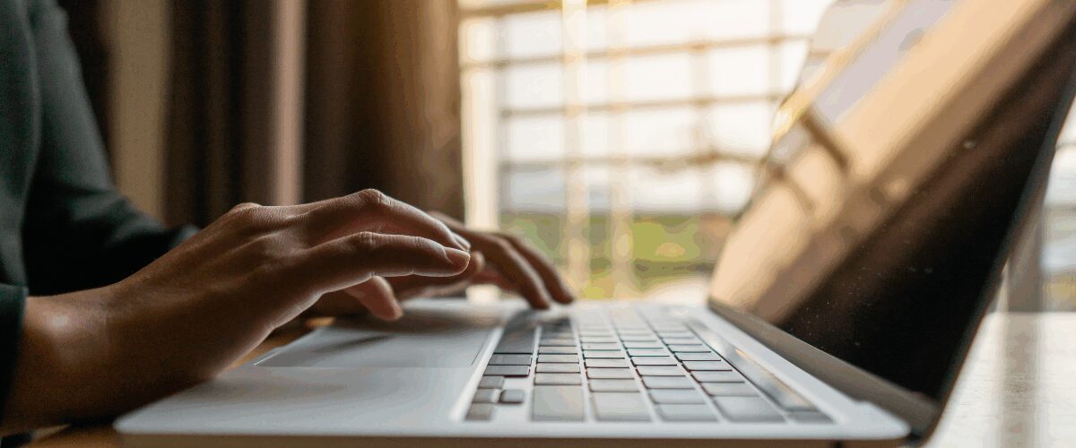 Close up of hands typing on a laptop.