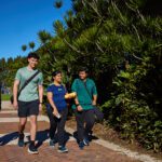 Four students walking outside Curtin Stadium.