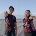 Kristel and Musa pointing at the camera at Cottesloe Beach.