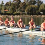 Students rowing together on calm water during a beginner rowing session at Curtin.