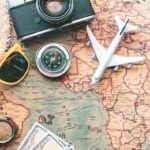 Map with sunglasses, hat and foreign money.