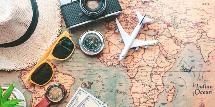 Map with sunglasses, hat and foreign money.