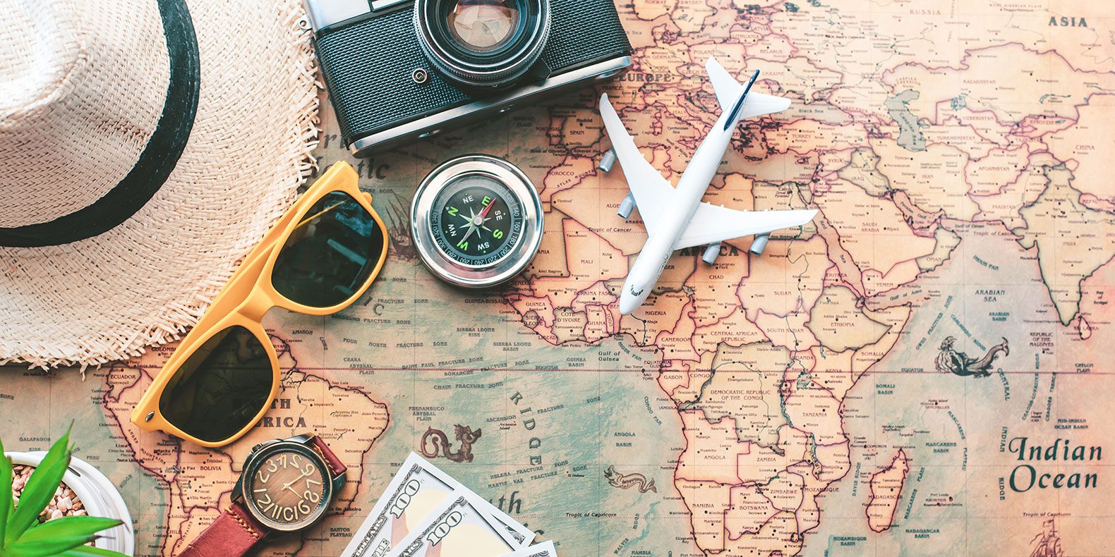 Map with sunglasses, hat and foreign money.