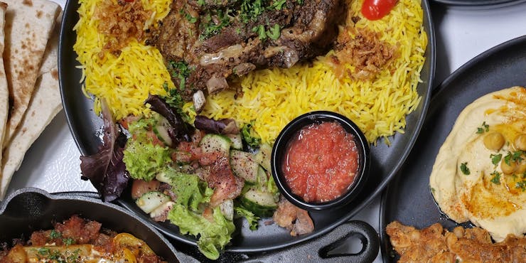 A delicious spread of Middle Eastern halal dishes including lamb and yellow rice, perfect for a vibrant meal.