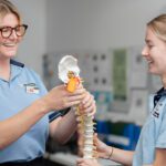 Physiotherapy students reviewing a spine model during clinic training.