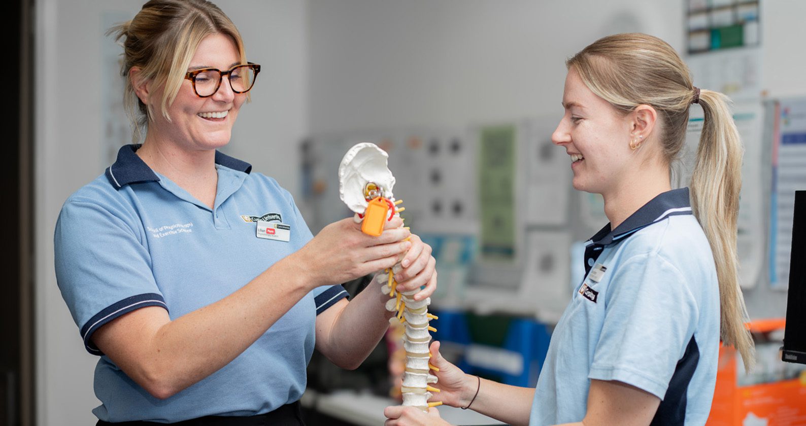Physiotherapy students reviewing a spine model during clinic training.